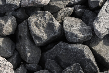 Dark gray stones covering the ground. Background photo texture