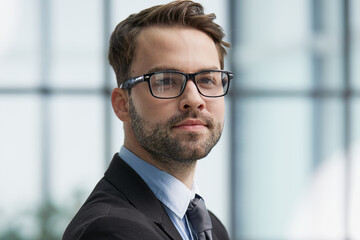 Portrait man wearing spectacles and looking at camera indoor.