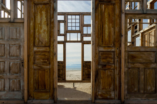 Sea ​​view through wooden structures made of old doors and windows. "Wind Pavilion" by Ēriks Božis on the Liepāja beach. Latvian visual public art program "Together".