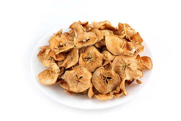 Dried apple slices in a white plate on a light background.