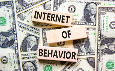 Internet of behavior symbol. Concept words Internet of behavior on wooden block on a beautiful background from dollar bills. Dollar bills. Business Internet of behavior concept. Copy space.