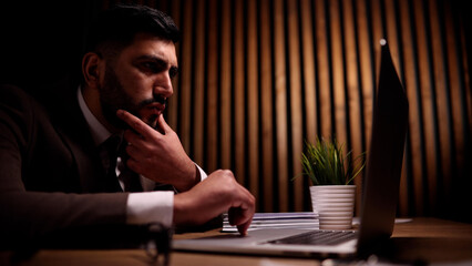 Business male is sitting in front of a laptop