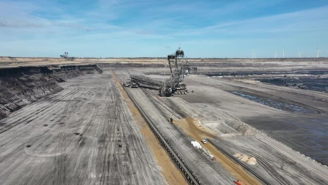 Get a unique and breathtaking view of the excavation process as you soar above this open pit mine and its enormous mining machines.