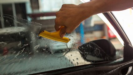 Technician Installing car window tint. Car window tinting series. Car window tinting specialist...