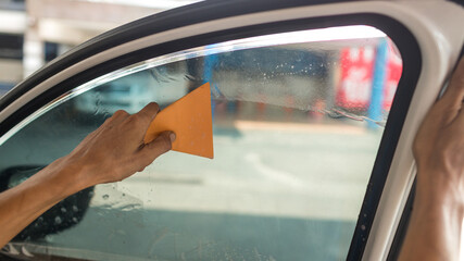 Technician Installing car window tint. Car window tinting series. Car window tinting specialist...