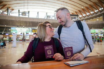 Two Italian tourists with passports in hand at the airport look at each other, travelers in love