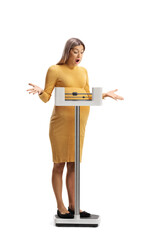 Surprised pregnant woman weighing on a medical scale