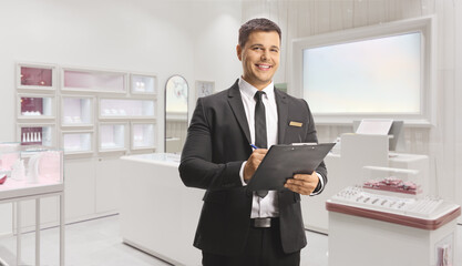 Jewelry shop manager holding a document in a shop