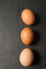 Raw of fresh eggs, on a black table