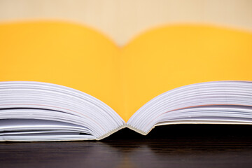 Close-up of an open thick book with orange pages