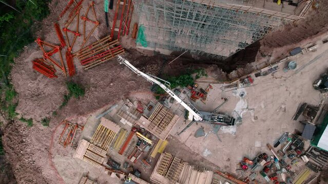 Construction of overpass structure with supports for bridge aerial view. Equipment for development of transport bridge with concrete pump truck on site
