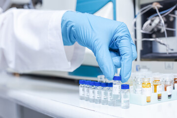 A hand of scientists arrange vials of samples in order of sample or prepare samples for analysis by Liquid Chromatography mass spectrometry LC-MS analysis in lab. LC-MS is used for scientific research - obrazy, fototapety, plakaty