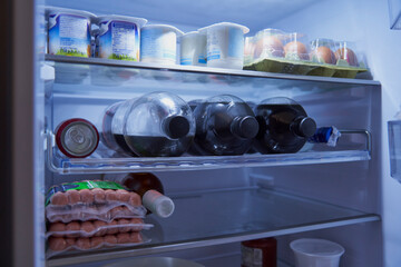 close-up of food and drink inside an open fridge