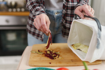 Cook throwing food peels in a compost bin with bokashi. Responsible female person recycling organic waste into natural fertilizer. Sustainable lifestyle concept