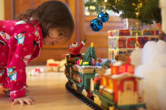 Little Girl Looking at Toy Train