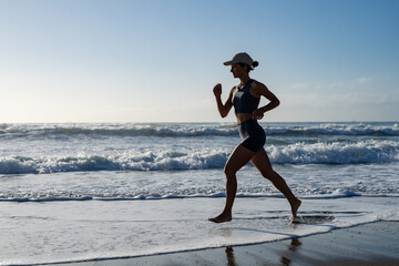 beautiful young girl is engaged in jogging on the seashore front view