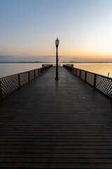 Fototapeta premium wooden pier over lagoon during sunrise