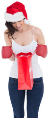 Happy brunette in boxing gloves looking in shopping bag