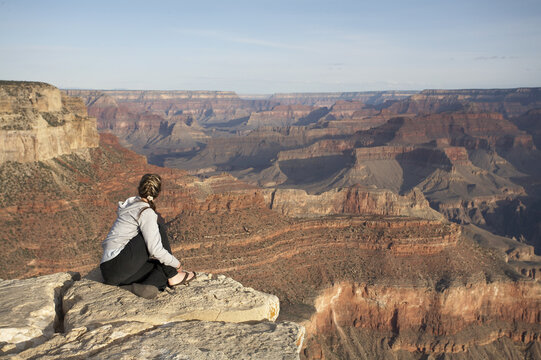 Woman Sitting on Rock, Overlooking Grand Canyon, Arizona, USA