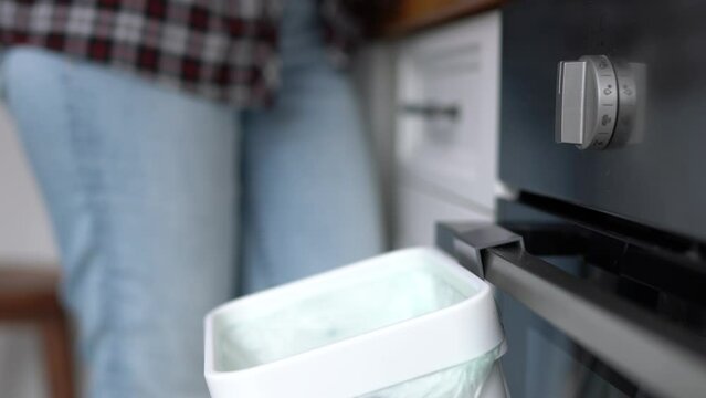 Woman recycling organic food leftovers in a bokashi container with ferment. Female person throwing compostable waste in a domestic compost bin