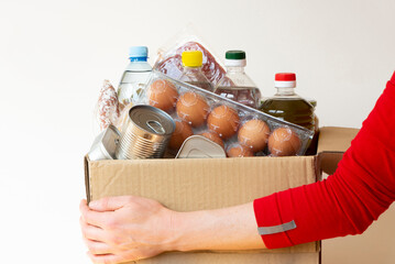 A volunteer holds a box of food for the poor. Donations and assistance to low-income families, orphans, refugees