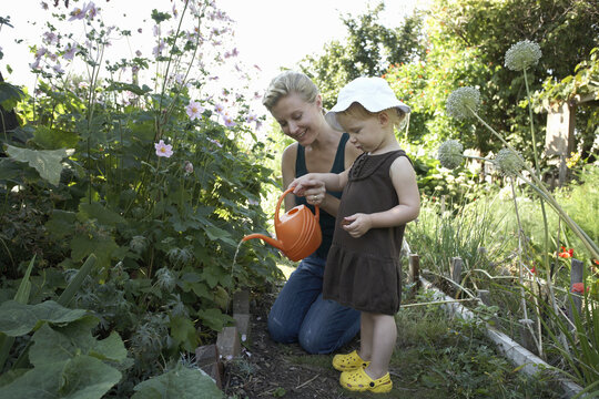 Mother and Daughter in Garden Watering Plants, Vancouver, British Columbia, Canada