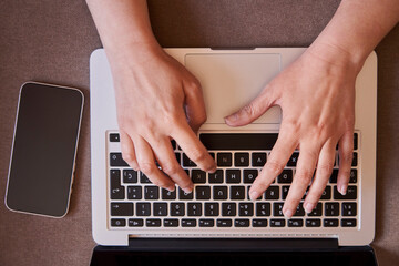 Fototapeta na wymiar Close-up of the hands of businesswoman typing with a laptop