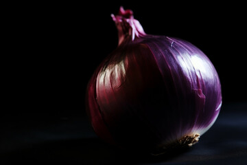A purple onion on a table with the light shining on it.