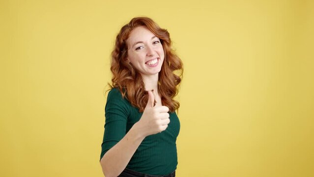 Happy redheaded woman gesturing agreement raising a thumb up