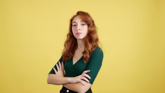 Serious redheaded woman standing with arms crossed