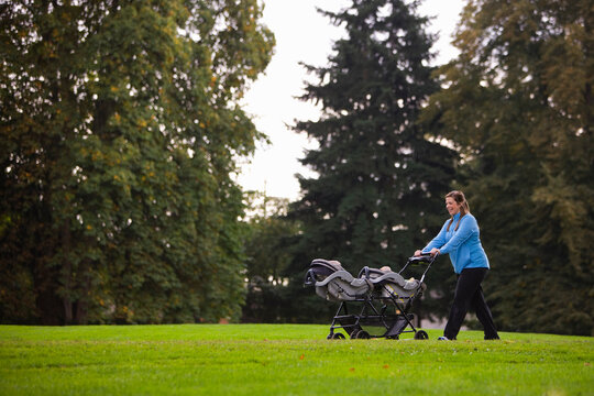 Woman Pushing Stroller in Park, Seattle, Washington, USA