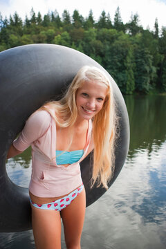 Woman on Dock Holding an Inner Tube, Near Portland, Oregon, USA