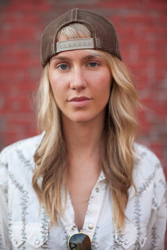 Close-up Portrait of Woman Standing in Front of Brick Wall