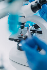 biochemical research scientist team working with microscope for coronavirus vaccine development in pharmaceutical research labolatory, selective focus