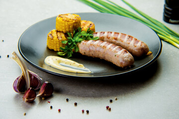 homemade sausages and grilled corn with sauce for online restaurant menu on gray background