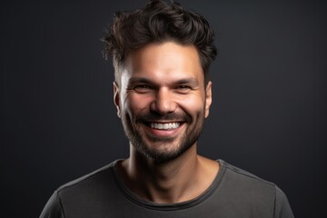 Obraz premium Portrait of a happy young man on a black background. Close-up.