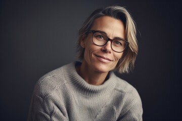 Portrait of mature woman with eyeglasses looking at camera against grey background
