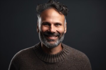 Obraz premium Portrait of a handsome bearded man in a sweater on a dark background