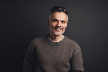 Fototapeta premium Handsome middle-aged man in a sweater on a dark background