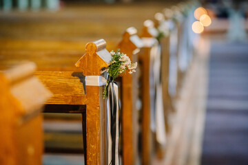 Flowers added to the ends of chairs in the church