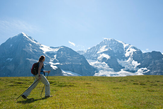 Woman Hiking using Walking Sticks, Bernese Oberland, Switzerland