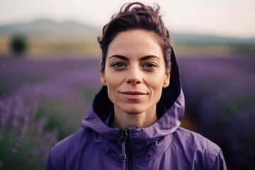 Portrait of young woman standing in lavender field and looking at camera