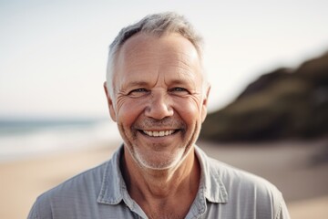Fototapeta na wymiar Portrait of smiling senior man standing on beach on a sunny day