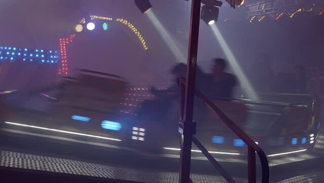 People having fun riding roller coaster at the amusement park at night