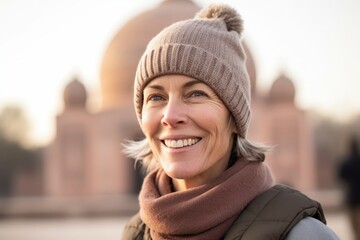Portrait of smiling middle-aged woman in hat and scarf outdoors