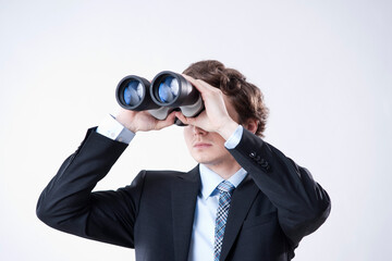 Young Businessman Looking through Binoculars