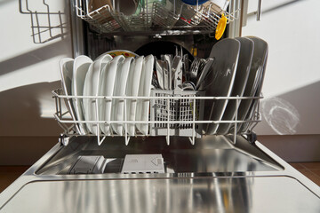 Front view of dishes and utensils in a dishwasher