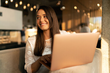 Portrait of a young smiling woman working on the laptop