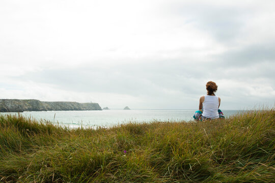 Woman Sitting and Looking into the Distance at the Beach, Camaret-sur-Mer, Crozon Peninsula, Finistere, Brittany, France