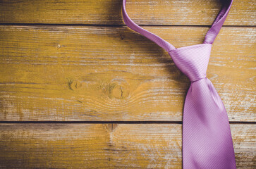 Elegant purple tie on yellow wooden background